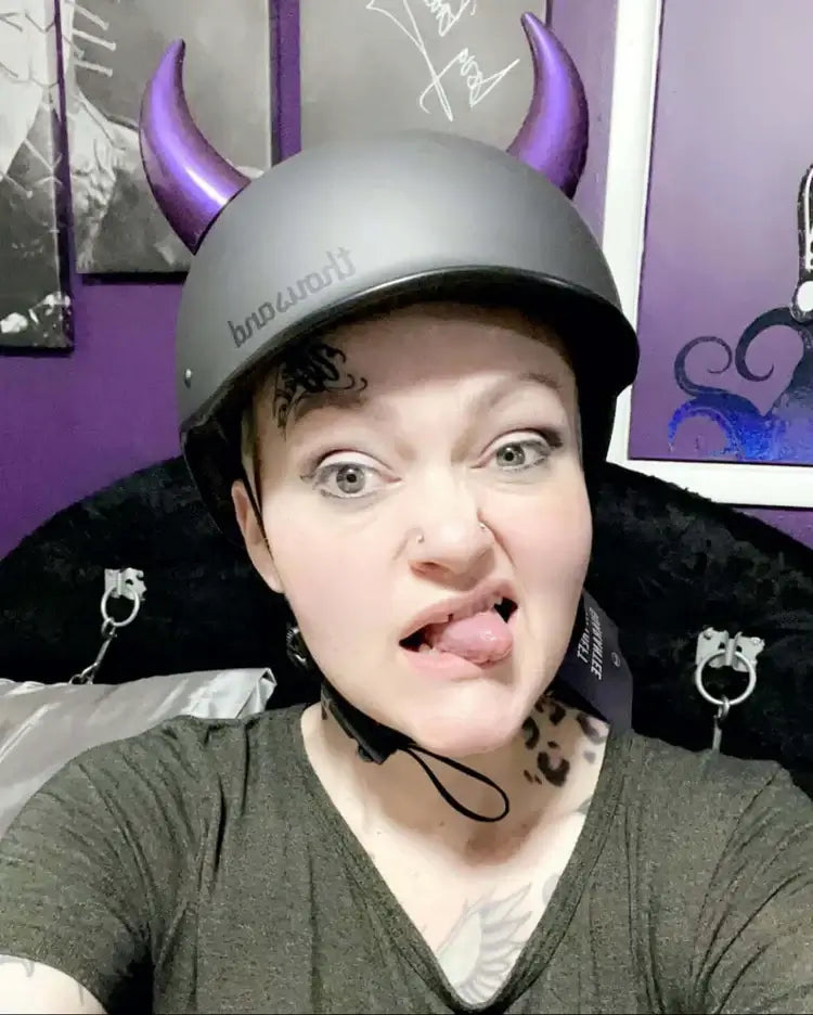Helmet Flair MagNeatOhz purple horns being modeled by a woman sticking her tongue out at the camera