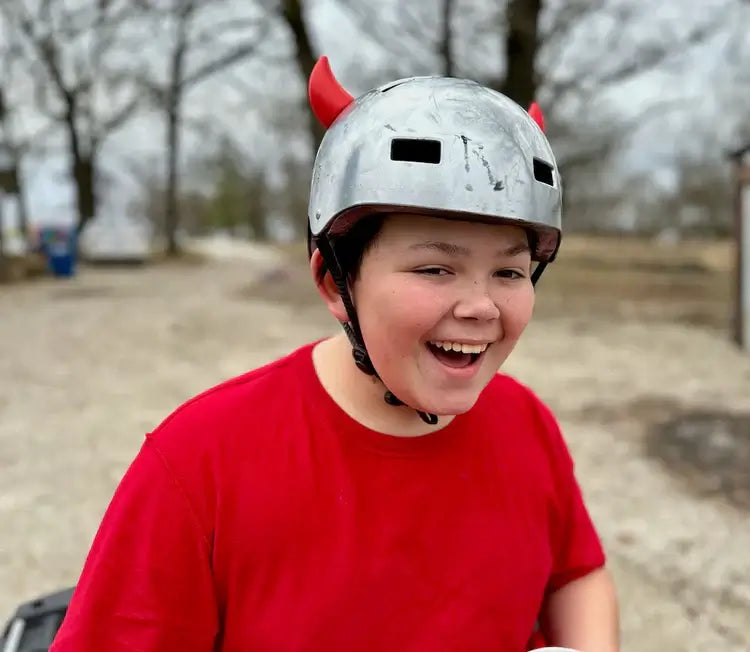 young boy smiling as he models his helmet flair devil horns