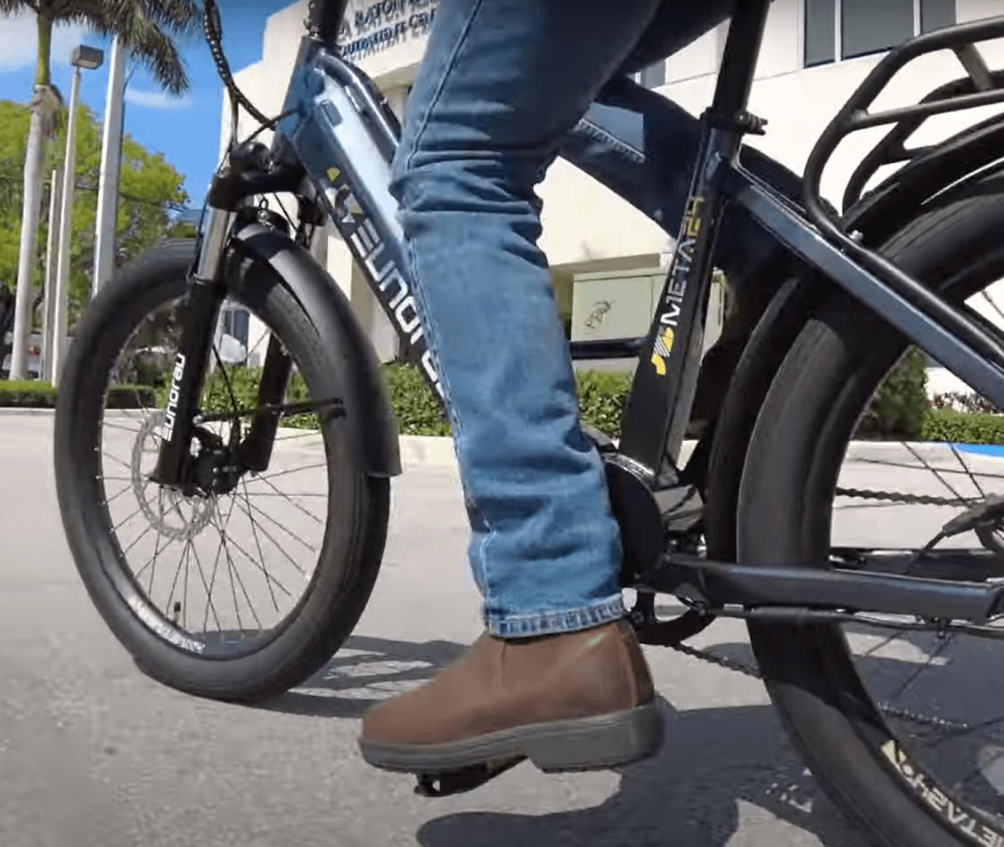 Commuter ebike collection image showing a man pedaling his ebike near an office building