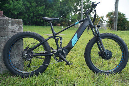 EUNORAU DEFENDER-S e-bike with fat tires, full suspension, and dual 750W motors shown in a grassy outdoor setting.